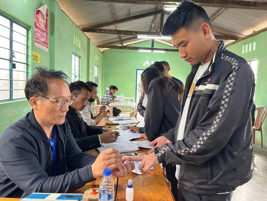 A polling official administering indelible ink to a voter, at a polling booth, during the 1st Phase of General Elections-2024 at Kohima